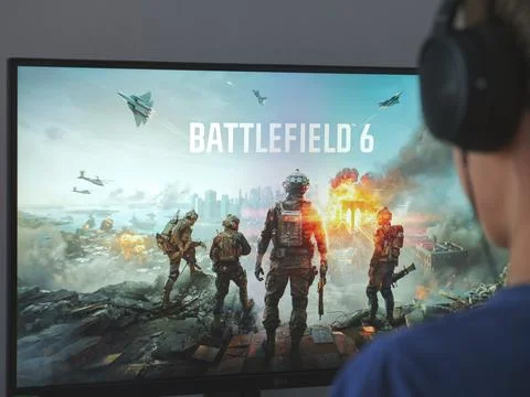 A young man sitting behind a computer with the Battlefield 6 game. Stock Photos