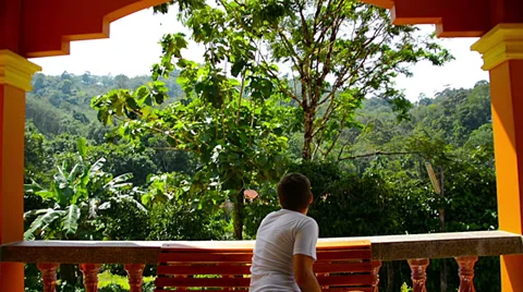 Young man sitting on a bench on the balcony at home Video stock 33474894