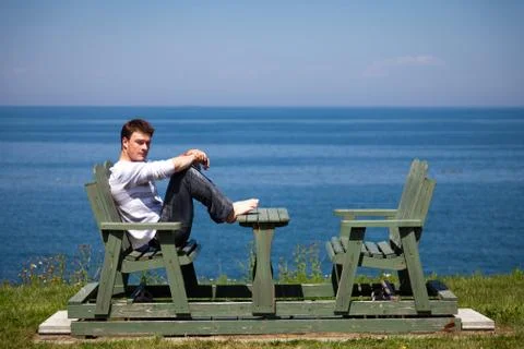 Young man sitting on the bench Stock Photos