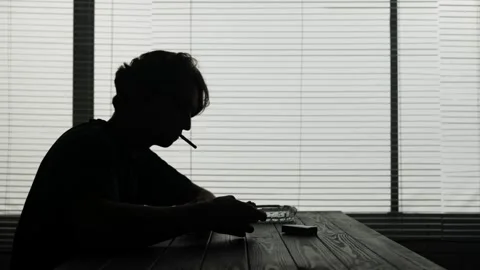 A young man is sitting in a cafe. He is frustrated, sad. Then takes a cigarette Stock Footage 252405537