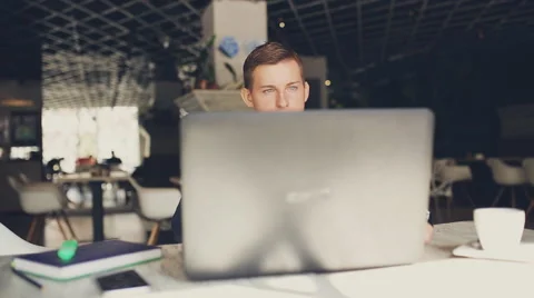 Young man sitting in cafe with laptop and coffee. 스톡 동영상 67393853