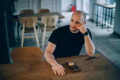 A young man is sitting in a cafe. Stock Photos