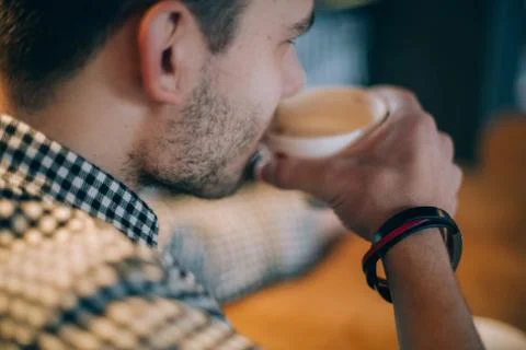 A young man is sitting in a cafe. Stock Photos
