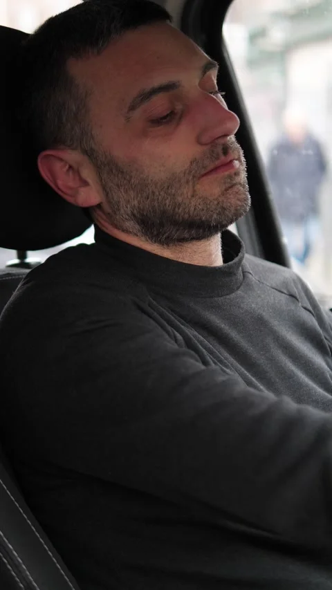 Young man sitting in car feeling sad and emotionally exhausted Stock Footage 332417979