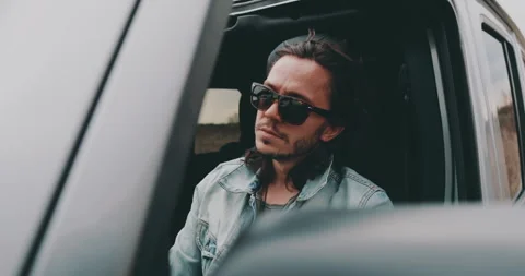 A young man is sitting in a car Stock Footage 240701990