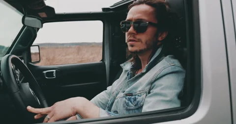A young man is sitting in a car Видео 240702210