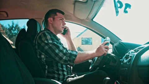 A young man sitting in the car talking on the phone. Stock Footage 150153221
