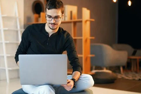 Young man sitting with computer. Freelancer in glasses working with laptop Stock Photos