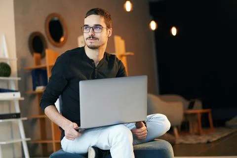 Young man sitting with computer. Freelancer in glasses working with laptop Stock Photos