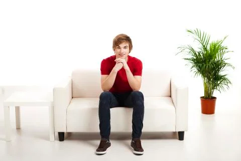 Young man sitting on the couch Stock Photos
