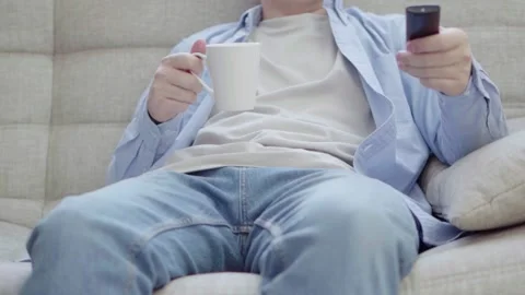 A young man is sitting on the couch watching TV Stock Footage 172543747