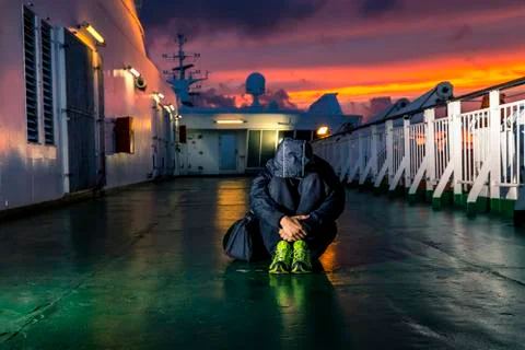 Young man is sitting on the deck during sunset Stock Photos