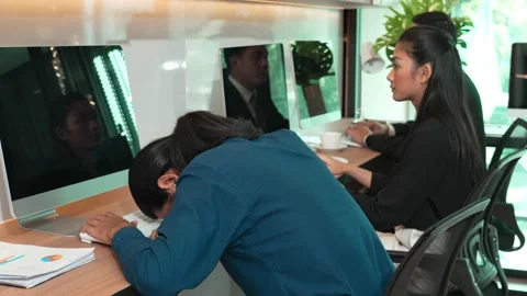 Young man sitting at desk in front of laptop in modern office Stock Footage 171967054