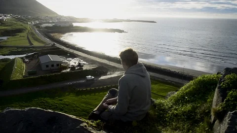 Young man sitting down and looking at Olafsvik,Silhouette Opportunity Searching2 Stock Footage 83309668