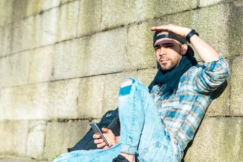 Young man sitting on the floor using mobile phone. Stock Photos