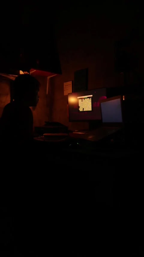 Young man sitting in front of the computer at night in a dark room Video stock 260373671