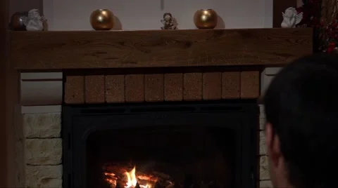 Young Man Sitting In Front Of A Fireplace Stock Footage 44014959
