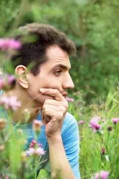 Young man sitting in the grass Stock Photos