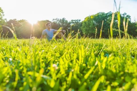 A young man sitting in the Grass Stock Photos