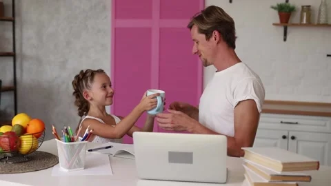 Young man sitting at home working on laptop with his daughter Stock Footage 160351164
