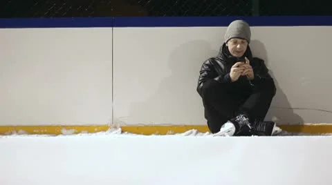 Young man sitting on the ice and texting Video stock 10739206