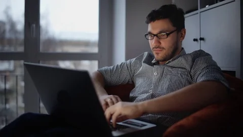 Young man sitting with laptop Stock Footage 85140369