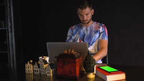A young man is sitting at a laptop. Stock Footage 109418317