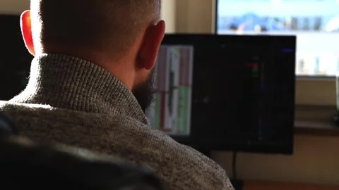 Young man sitting looking at the graph on the monitor Stock Footage 242719791