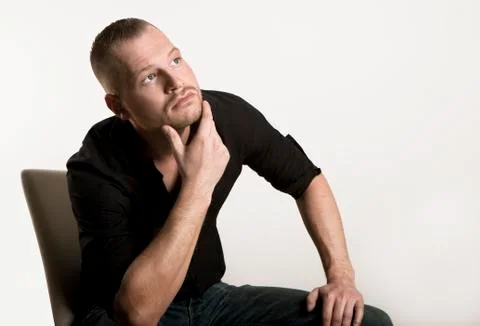 Young man sitting looking up Stock Photos
