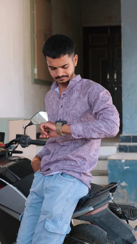 Young Man Sitting on Motorcycle Checking Time on Wristwatch While Waiting Видео 330738274