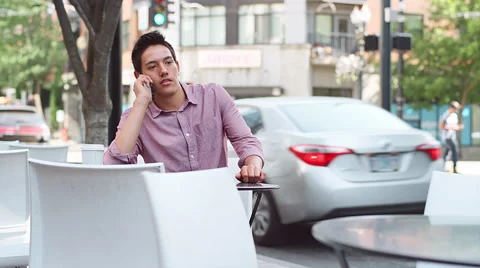 A young man sitting outside talking on his phone Stock Footage 57624415