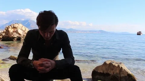 Young Man Sitting over a rock Stock Footage 83267295