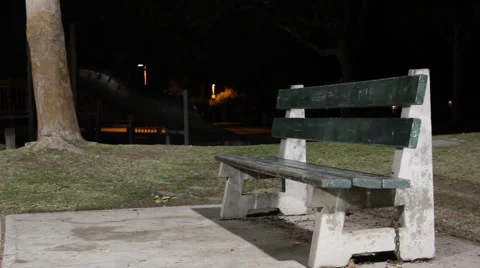A young man sitting on a park bench getting ready to play basketball on an outdo 스톡 동영상 68541177