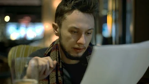 Young man sitting in the pub and learning notes by heart for the exam 库存影片 73105688