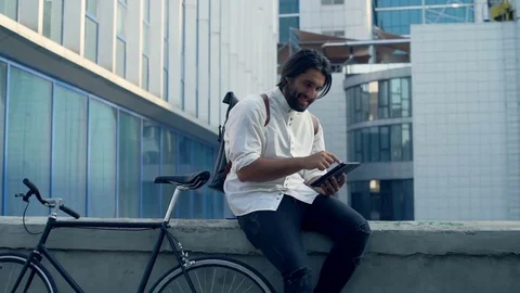 Young man sitting on the railing with his tablet slow motion Stock Footage 79240099