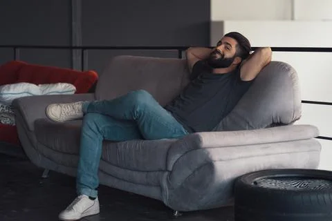 Young man sitting relaxing on the couch Foto stock