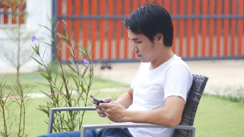 Young man sitting with smartphone Stock Footage 71756397