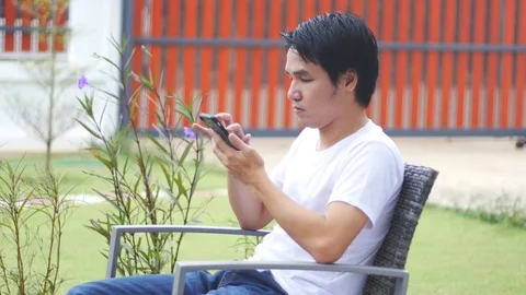 Young man sitting with smartphone Stock Footage 71756786