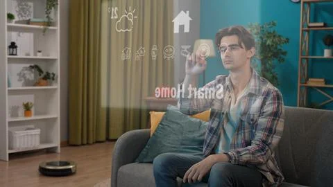 Young man sitting on the sofa and using visible virtual reality touch screen 写真素材