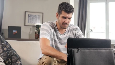Young Man sitting on the Sofa have a Video Call with Mother on digital Laptop pc Stock Footage 93943612