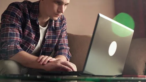 Young man sitting on sofa with laptop, working from home concept. remote work. Stock Footage 211812103