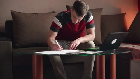 Young man sitting on sofa with laptop, working from home concept. remote work. Stock Footage 211812765