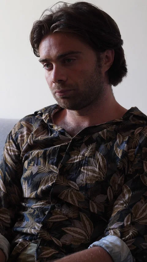Young man sitting on sofa, sad after being left by partner 스톡 동영상 321541370