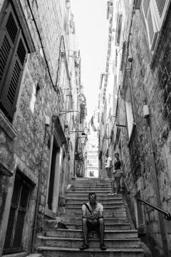 Young Man Sitting on a Steps in old Town Stock Photos