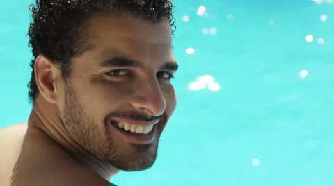 Young man sitting in swimming pool on vacation Stock Footage 5544055