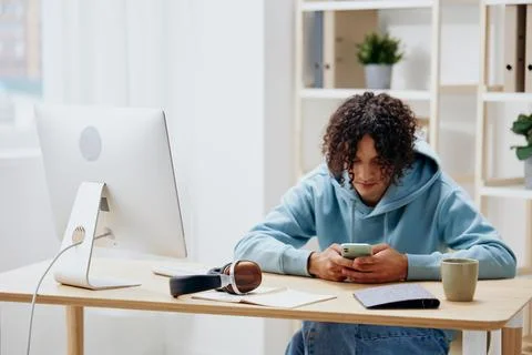 A young man sitting at a table in front of a computer freelance Lifestyle Stock Photos
