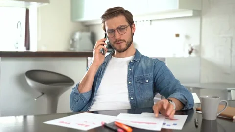 Young man sitting at table, holding negotiations cellphone call with client Stock Footage 155332316