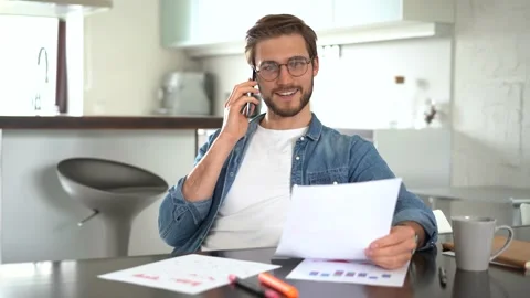 Young man sitting at table, holding negotiations cellphone call with client Stock Footage 155332317
