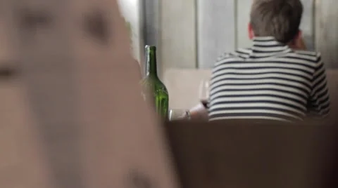 Young man sitting at a table in the restaurant and the menu Видео 58856387