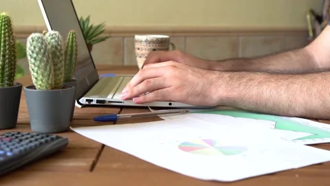 Young man sitting at table typing on a laptop during work remotely from home Stock Footage 162560955